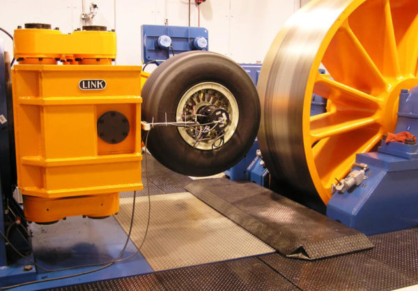 The Model 8700 Aircraft Roll Dynamometer, depicted here, is used for laboratory testing of aircraft wheels to measure the performance of wheel designs.